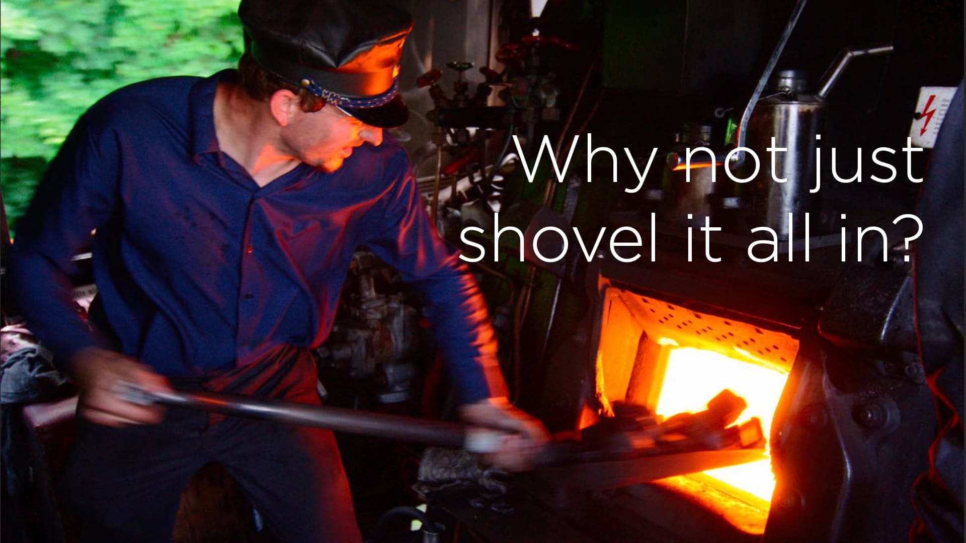 man shoveling coal into locomotive